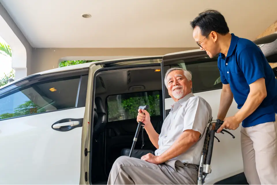 Man assisting elderly person in wheelchair