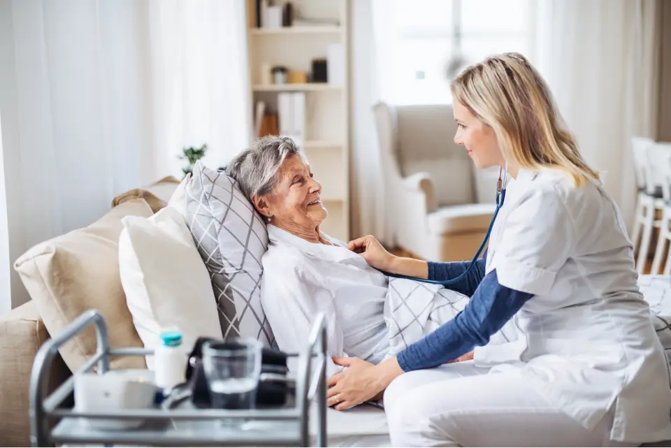 Nurse caring for elderly patient at home.