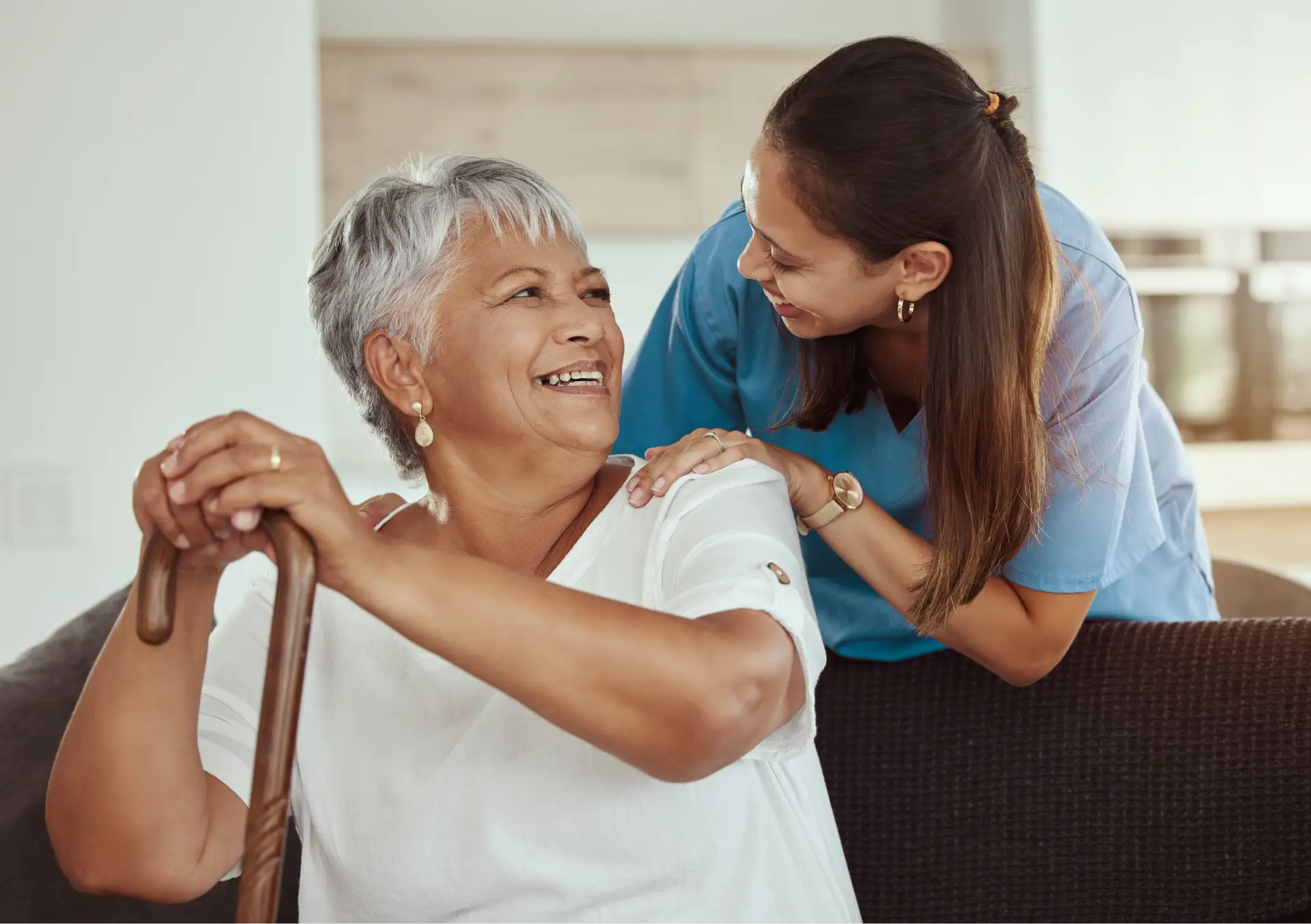 Caregiver assisting elderly woman at home.